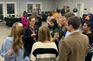 Sarah Taber in a room full of voters, talking with a group.